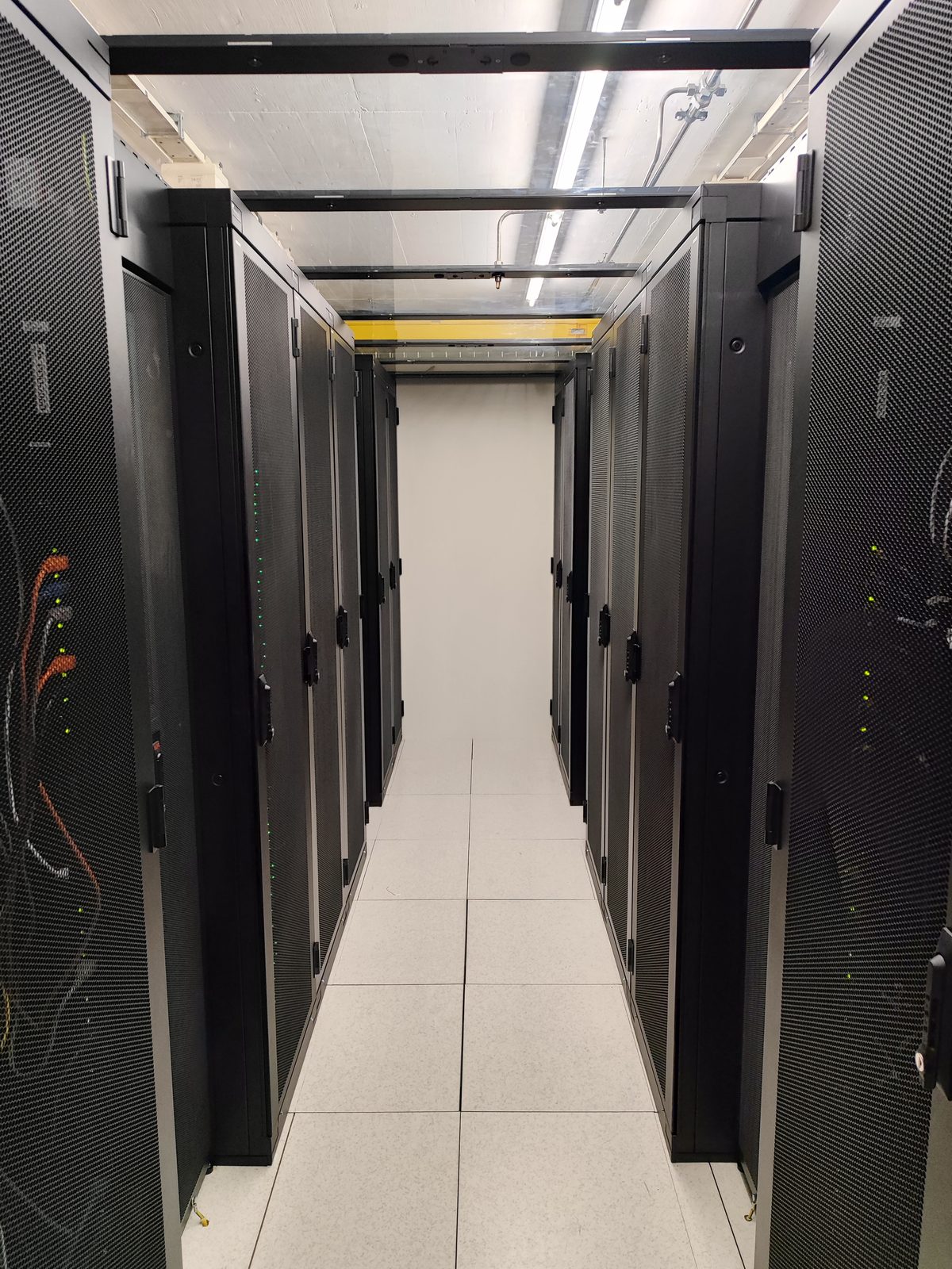 Rangées de baies haute densité dans le hot corridor du datacenter Crissier