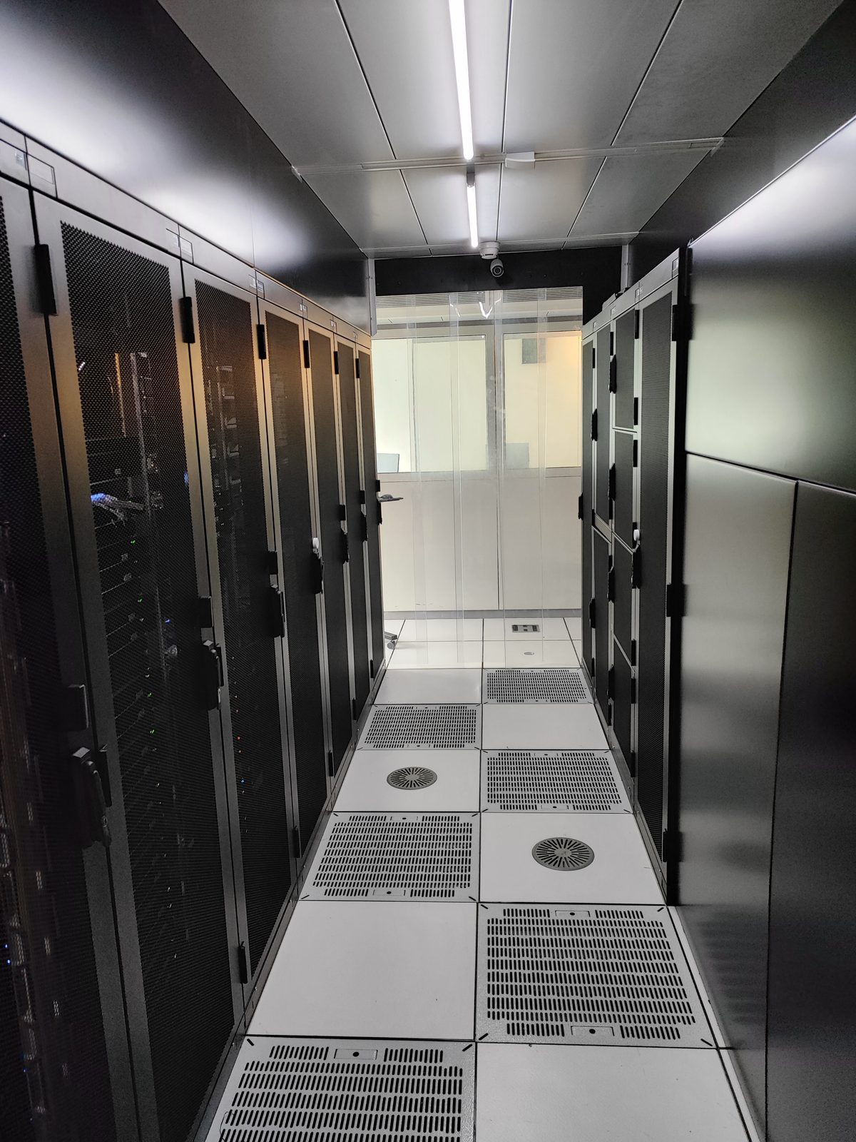 Cold corridor du datacenter AlpineDC de Lausanne avec rangées de baies informatiques